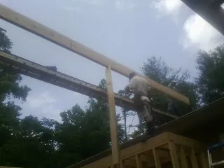 Carpenter setting a ridge beam over a new addition frame — Ice Dam Removal by Roofing Brothers in Kimballton