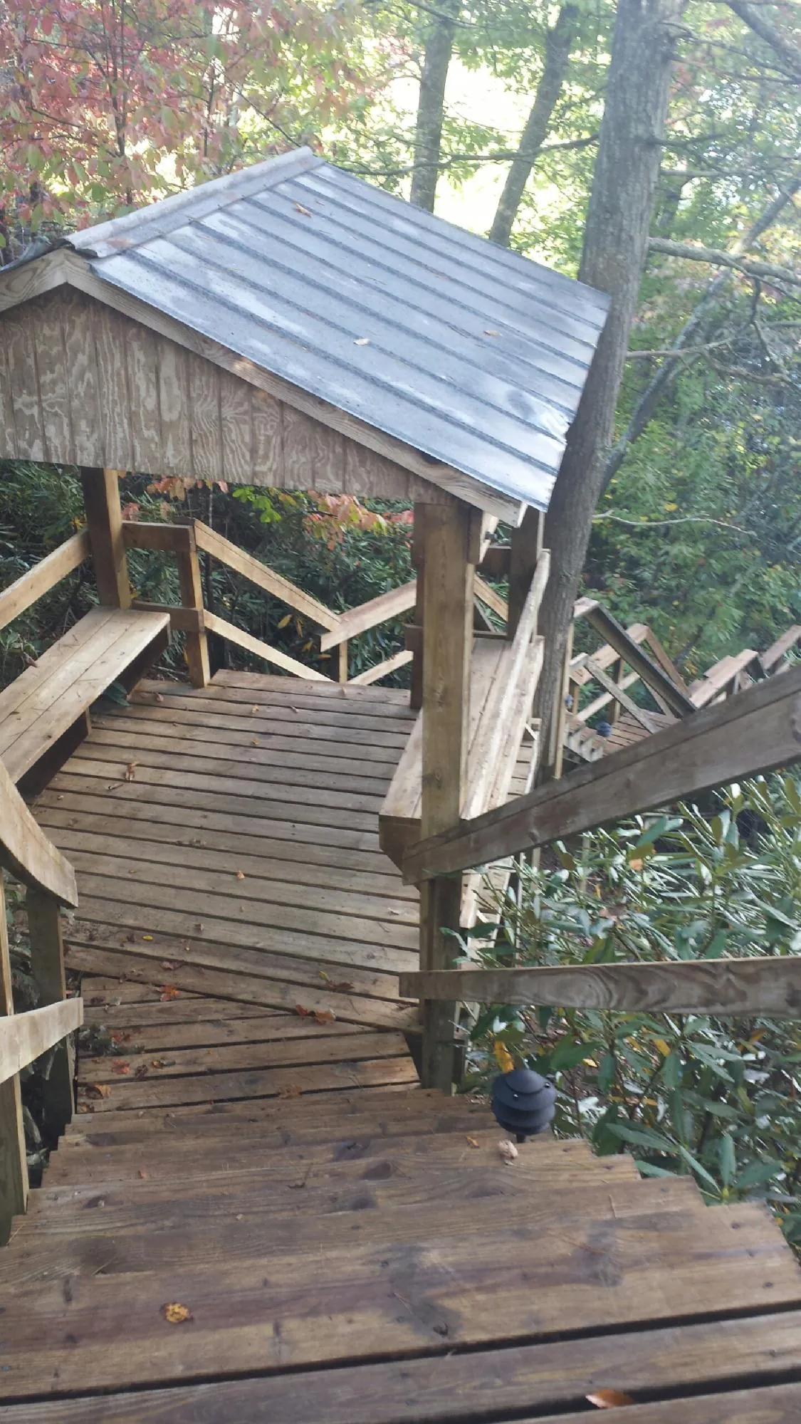Metal roofed shelter over wooden steps on a wooded walkway — Skylight Repair & Installation work by our crew in Kimballton