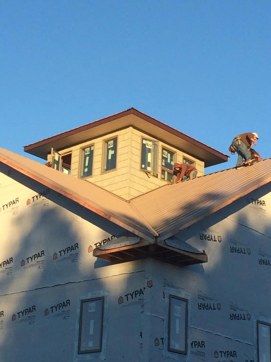 Roofers working around a rooftop cupola on a new metal roof at sunset — Roof Waterproofing in Kimballton by Roofing Brothers